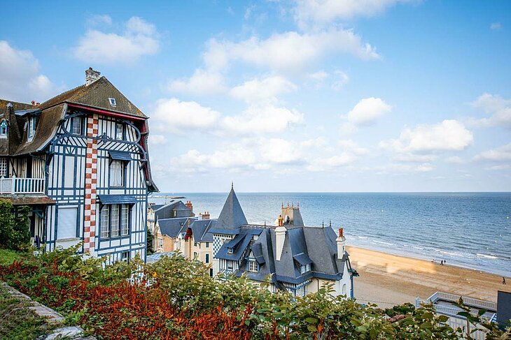 Belle Époque villas overlooking Deauville beach in Normandy, a calm sea and a seaside promenade, a relaxing getaway for retirees.