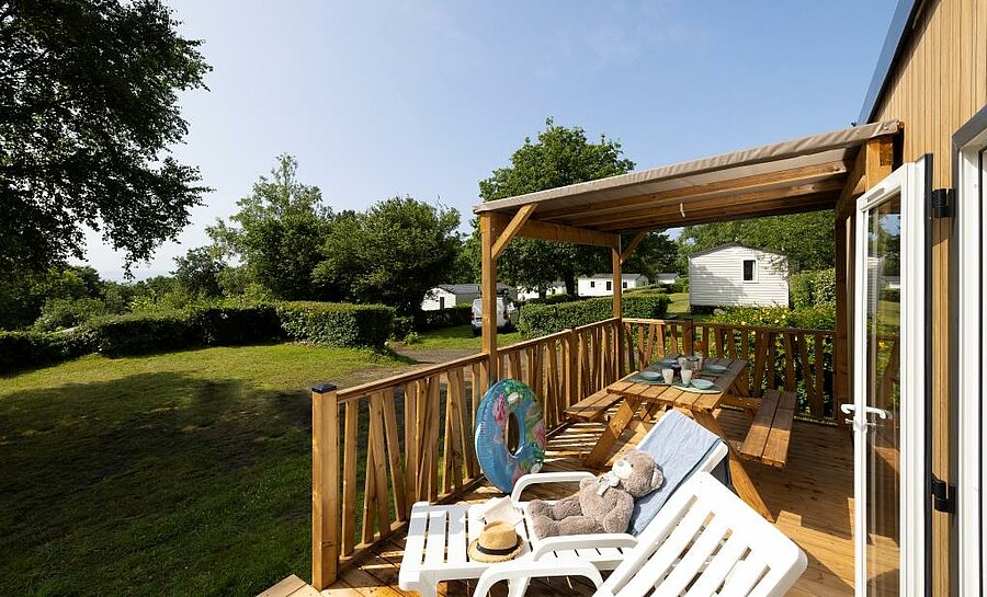 Wooden terrace of a mobile home at Le Panoramic campsite, a comfortable rental near Moëlan-sur-Mer for outdoor holidays.