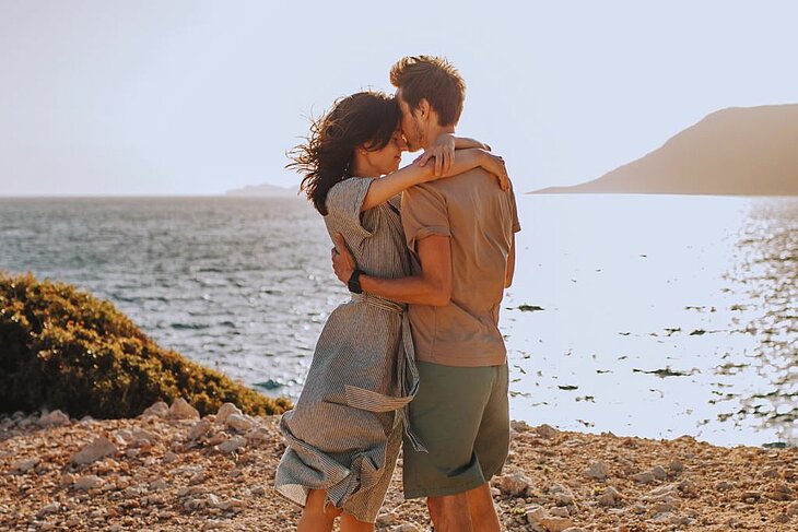A couple embracing by the sea at sunset, a moment of calm and disconnection during a nature-filled getaway for two.