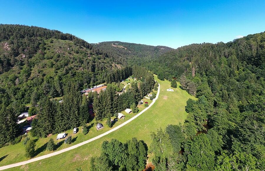 Campsite nestled in a green valley in Haute-Loire, surrounded by forests and hills in the heart of Auvergne