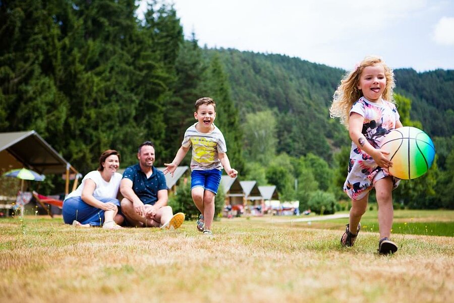 A family enjoying an Easter weekend camping with Sites et Paysages, surrounded by nature, combining relaxation and outdoor play.