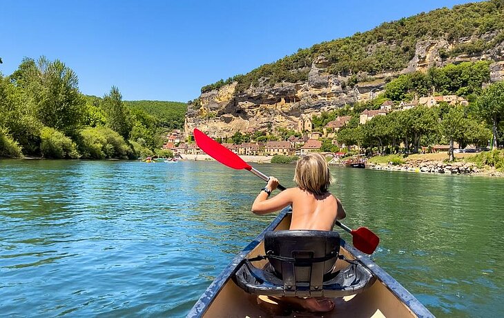 Canoeing on the Dordogne River Child canoeing on the Dordogne River near a village in Périgord, a must-do activity for visitors to Nouvelle-Aquitaine.