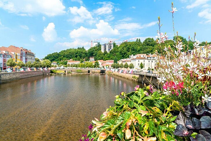View of Épinal with its flower-lined quays and colorful buildings, showcasing the charm of the character towns in the Vosges.