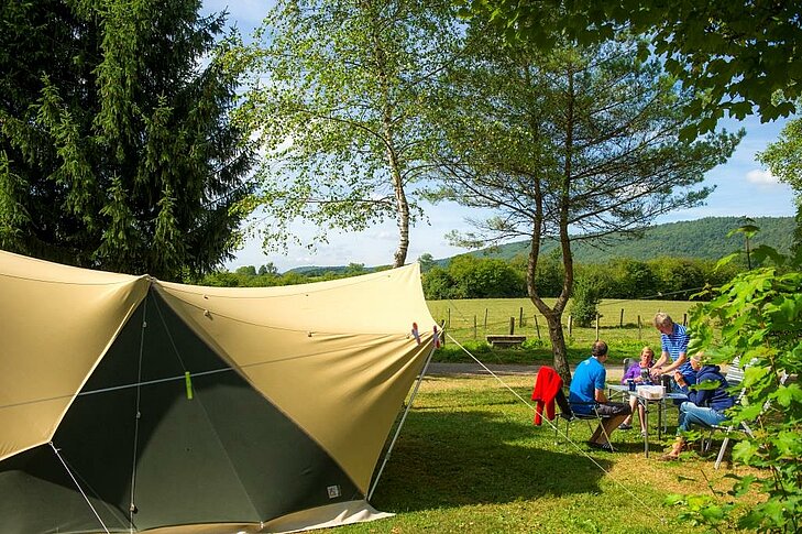 Family settled on a spacious, green pitch at Sites et Paysages Beauregard, enjoying a comfortable break around Mesnois.