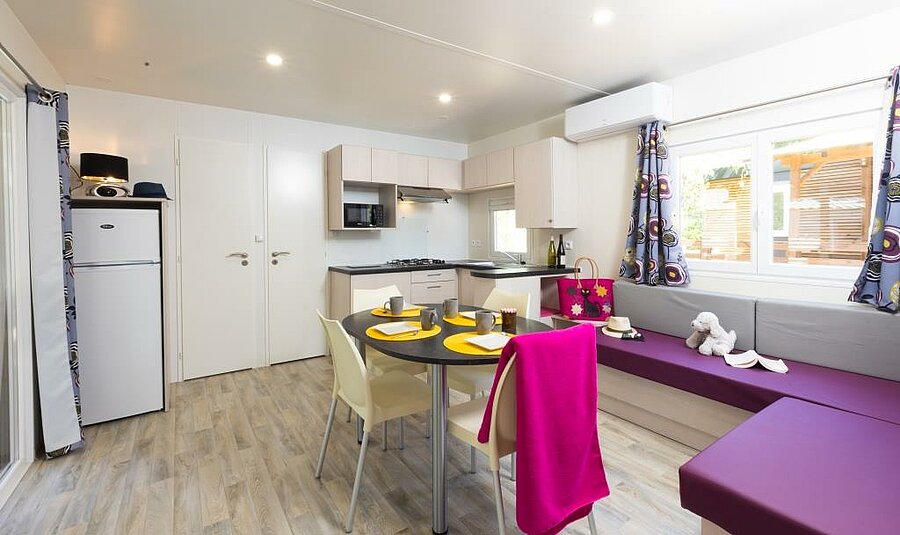 Living room and kitchen of an air-conditioned mobile home, perfect for a cool family holiday, even in the middle of a heatwave.
