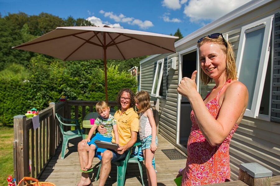 A family enjoying a stay in a mobile home during an Easter weekend camping trip with Sites et Paysages, under beautiful spring sunshine.