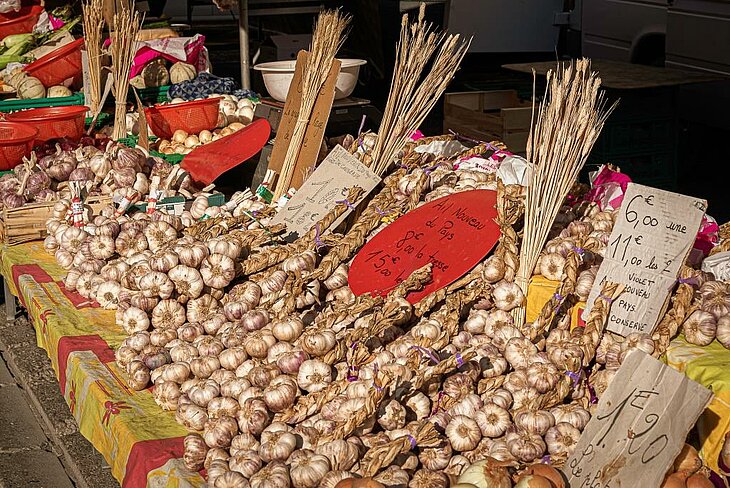Stall selling garlic and local produce at the Provençal market in Vaison-la-Romaine.