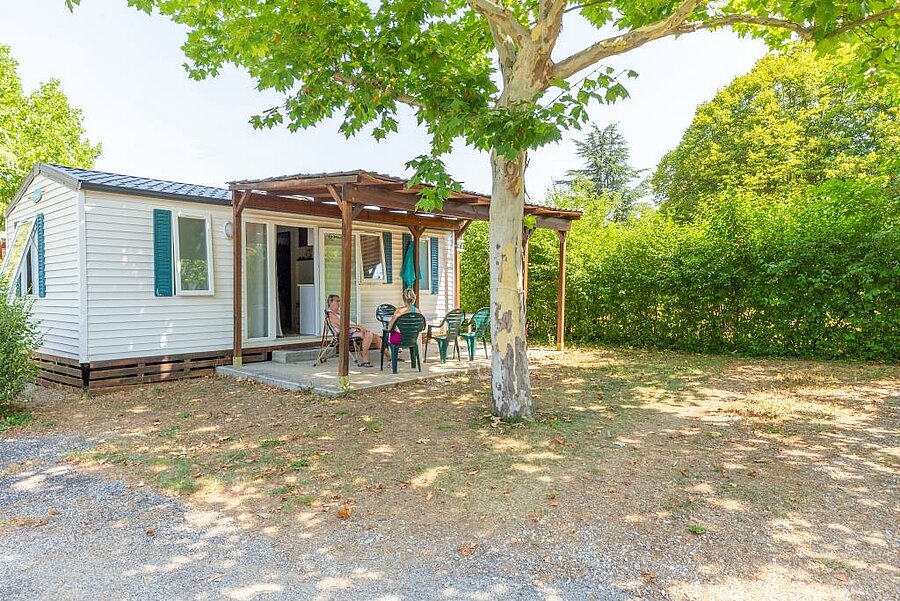 Mobile home with a shaded terrace at a campsite in the Alpes-de-Haute-Provence, offering comfort and peace for a family holiday.