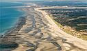 [Translate to Anglais:] Vue aérienne spectaculaire de la baie de Somme, avec ses étendues de vasières, marais et canaux naturels formant un paysage unique et préservé.