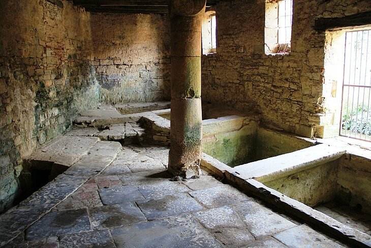 Former tanneries in Saint-Antonin-Noble-Val Stone interior of the former tanneries in Saint-Antonin-Noble-Val, featuring tanning vats and a central pillar.